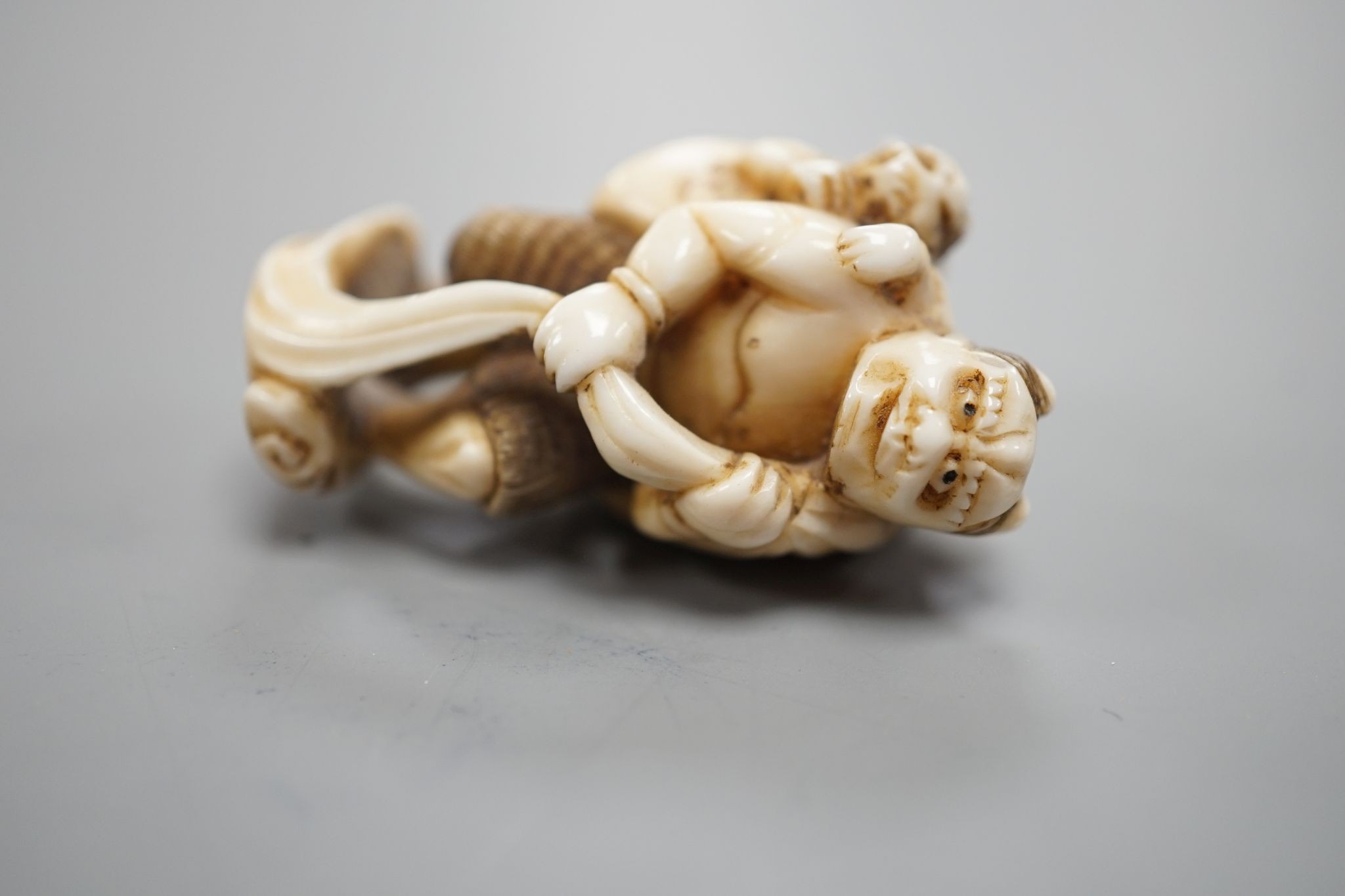 A Japanese ivory netsuke of oni, Meiji period, 4 cms high.